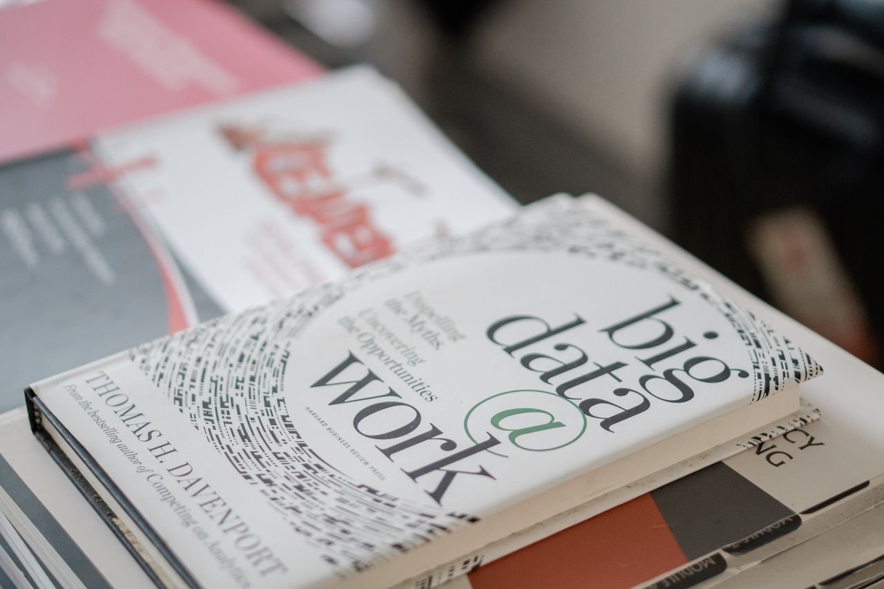 Close-up of books on data analytics and business strategies on a desk.